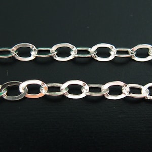 May include: A silver chain with oval links. The chain is made of metal and has a shiny finish.