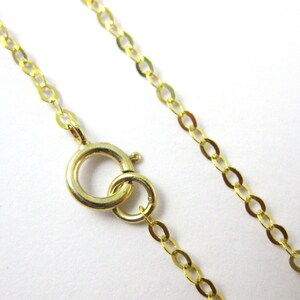 May include: A gold chain necklace with a lobster clasp closure. The chain is made of small, oval-shaped links.