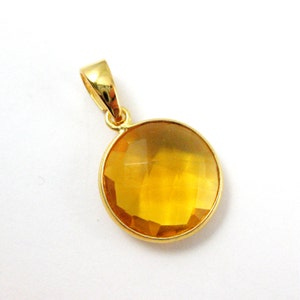 May include: A gold pendant with a round, faceted, yellow gemstone.