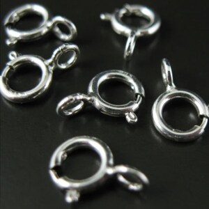 Puede incluir: Anillos de salto plateados, también conocidos como cierres de langosta, son un tipo de hallazgo de joyería. Estos anillos se utilizan para conectar cadenas, cordones u otros componentes de joyería.