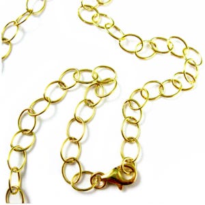 May include: A gold chain necklace with a lobster clasp closure. The chain is made of oval-shaped links.