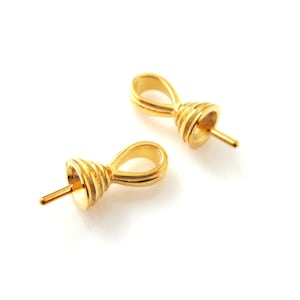 May include: Two gold-toned metal bead tips with a looped design. The tips have a pointed end for attaching to a string or cord.