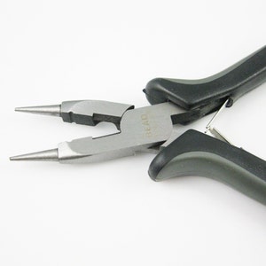 May include: Close-up of a pair of silver-toned jewelry pliers with black handles. The pliers have a pointed tip and the text "Bead Smith" is engraved on the side.