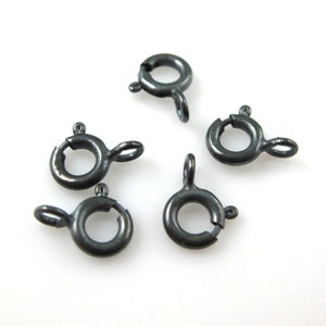 Puede incluir: Seis anillos de salto plateados con cierre de resorte. Los anillos de salto miden aproximadamente 1,25 cm de diámetro.