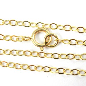 May include: A gold chain necklace with a lobster clasp closure. The chain is made of oval links.