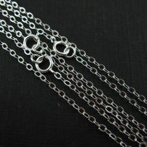 May include: Five silver chain necklaces of varying lengths, all with a classic oval link design.