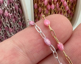 May include: Two strands of pink chain with oval-shaped links. One chain is silver and the other is gold.