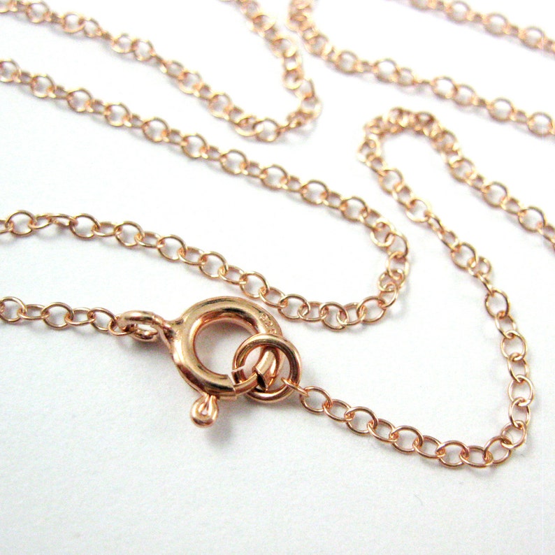 May include: A rose gold chain necklace with a lobster clasp closure.