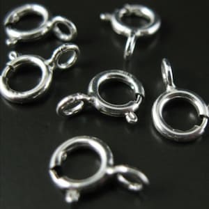 Puede incluir: Anillos de salto plateados, también conocidos como cierres de langosta, son un tipo de hallazgo de joyería utilizado para conectar cadenas, cordones u otros componentes de joyería. Estos anillos de salto son ideales para hacer collares, pulseras y otras piezas de joyería.