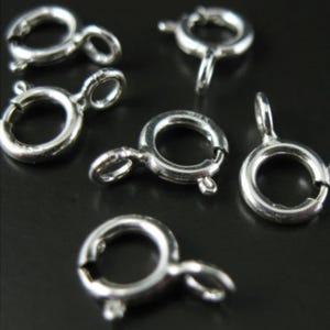 Puede incluir: Anillos de salto plateados, también conocidos como cierres de langosta, son un tipo de hallazgo de joyería utilizado para conectar cadenas, cordones u otros componentes de joyería. Estos anillos de salto son ideales para hacer collares, pulseras y otras piezas de joyería.