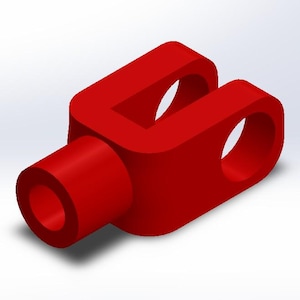 May include: A bright red, 3D-rendered yoke component. The part features a cylindrical projection on one side and a U-shaped section with two circular holes on the other. The design is simple and geometric.