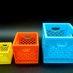 May include: Three plastic crate-style boxes in different sizes. The smallest is yellow, the middle is orange, and the largest is blue.