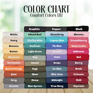 May include: Color chart displaying a variety of Comfort Colors 1717 fabric swatches. The chart features a range of colors, including white, black, and various shades of blue, green, yellow, orange, and red. The text "COLOR CHART" and "Comfort Colors 1717" are at the top.
