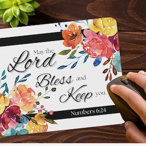 May include: White mousepad with floral watercolor design in shades of orange, pink, and yellow. The mousepad features the text "May the Lord Bless and Keep you. Numbers 6:24" in elegant script. A black computer mouse is on the right.