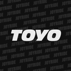 May include: A black background with the word "TOYO" in large, white, bold letters. The word "JOYRIDE" is repeated diagonally across the background in a lighter gray color.