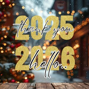 Puede incluir: Imagen festiva con los números 2025 y 2026 en purpurina dorada, con las palabras "thank you" y "hello" en escritura elegante. El fondo presenta luces navideñas borrosas y una superficie de madera.