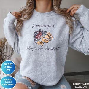 May include: Gray sweatshirt with the text "Neurosurgery Physician Assistant" and a stylized brain with flowers.