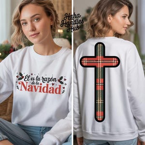 May include: White sweatshirt with the text "Él es la razón de la Navidad" in red and black. The back of the sweatshirt features a plaid cross design in red, green, and black. A festive holiday-themed apparel item.