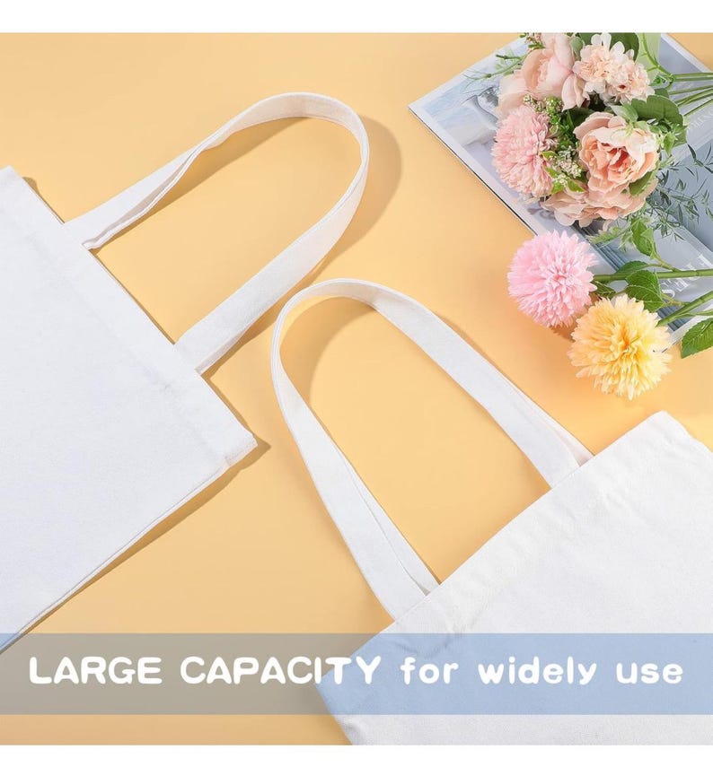 May include: Two white canvas tote bags with long handles, ideal for carrying items. The bags are displayed on a yellow background, with a bouquet of pink and yellow flowers in the background. The text "LARGE CAPACITY for widely use" is visible at the bottom.