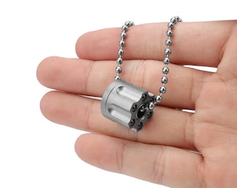 May include: A silver chain necklace with a silver bullet charm. The bullet charm has a detailed design and is a popular style for men.