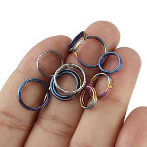 May include: A collection of colorful metal key rings in various sizes. The key rings are made of a durable metal and have a smooth, polished finish.