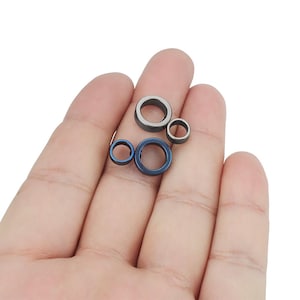 May include: Four metal rings in different sizes. The rings are silver and blue in color.