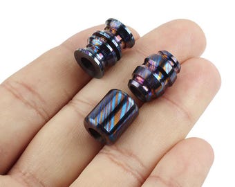 May include: Three colourful metal beads with a swirling pattern. The beads are made of stainless steel and have a blue, purple and gold colour scheme.
