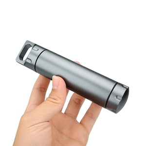 Könnte beinhalten: Ein zylindrischer, grauer Metallbehälter mit einer Schlaufe an einem Ende. Der Behälter wird in einer Hand vor weißem Hintergrund gehalten. Der Behälter scheint aus Metall zu sein und hat einen Schraubverschluss.