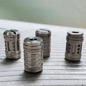 Peut inclure: Quatre jouets de fidget en métal argenté avec des designs différents. Chaque jouet est cylindrique et a une finition lisse et polie.