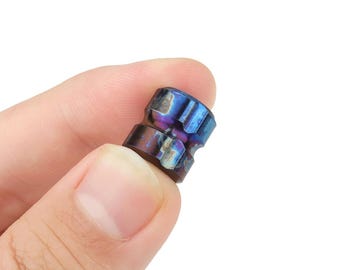 May include: A small, blue and purple metal fidget spinner with a textured surface.