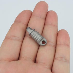 May include: A silver titanium keychain with a threaded design and a loop for attaching keys.