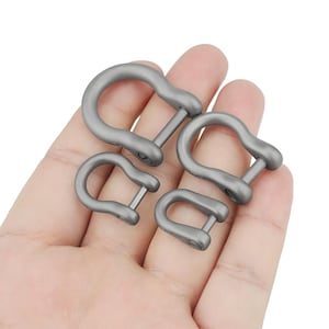 May include: Four silver metal D-rings of different sizes. The rings are held in a hand.