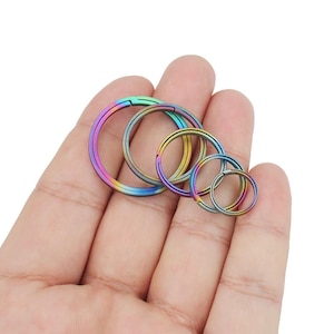 Puede incluir: Conjunto de cuatro llaveros de metal de diferentes tamaños, de color arcoíris.