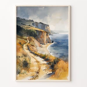 May include: A watercolour painting depicting a coastal scene with a winding path leading down to a sandy beach. The path is surrounded by green foliage and the beach is bordered by a rocky cliff. The ocean is a deep blue and the sky is a light grey with hints of clouds.
