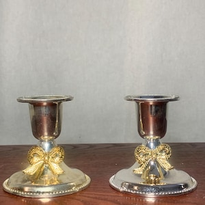 Par vintage silverpläterade ljusstakar med guldrosetter