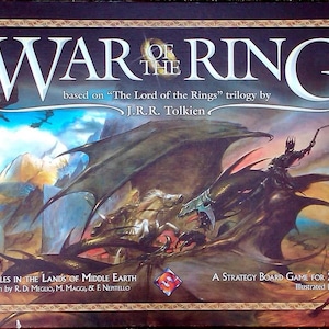 Puede incluir: Una caja de juego de mesa con una ilustración de fantasía de un dragón, un jinete y una escena de batalla. El título del juego es "War of the Ring" y está basado en la trilogía "El Señor de los Anillos" de J.R.R. Tolkien.