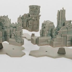 Peut inclure: Ensemble de bâtiments miniatures gris en ruine, probablement pour les jeux de société. Les structures sont détaillées avec des éléments architecturaux et montées sur des bases géométriques grises. La scène suggère un cadre post-apocalyptique ou fantastique.