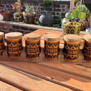A set of six vintage Hornsea Pottery ceramic spice jars in Heirloom pattern and brown glaze with tray in great condition.