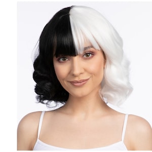May include: A two-toned wig with a black and white split design. The wig features a side part with black bangs and wavy, shoulder-length hair. The model is wearing a white tank top.