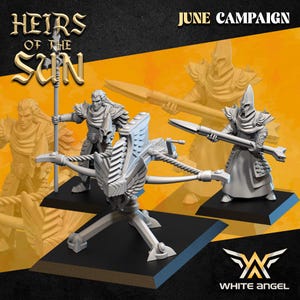 May include: A promotional image for the "Heirs of the Sun" June campaign, featuring miniature figurines. The image showcases a white, detailed crossbow, and several figures holding spears. The White Angel logo is visible in the bottom right corner.