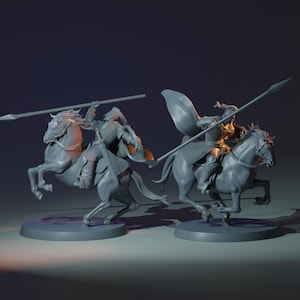 May include: Two grey unpainted miniature figurines of mounted warriors on horseback. Each rider wears chainmail armour and a flowing cape, holding a long spear. The horses are depicted in a dynamic galloping pose, both mounted on circular bases.