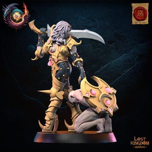 Könnte beinhalten: Miniaturfigur eines Kriegers in goldener Rüstung mit einer gebogenen Klinge. Der Krieger steht über einer knienden Figur. Dunkler Sockel, mit dem Text "Lost Kingdom - miniatures."