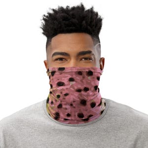 May include: A person wearing a pink and black patterned face covering. The pattern resembles a camouflage design.