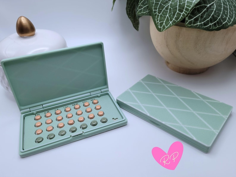 Open mint sea green diamond-pattern birth control pill holder with matching cases – shows compact custom 3D printed case in pastel green with white trim.