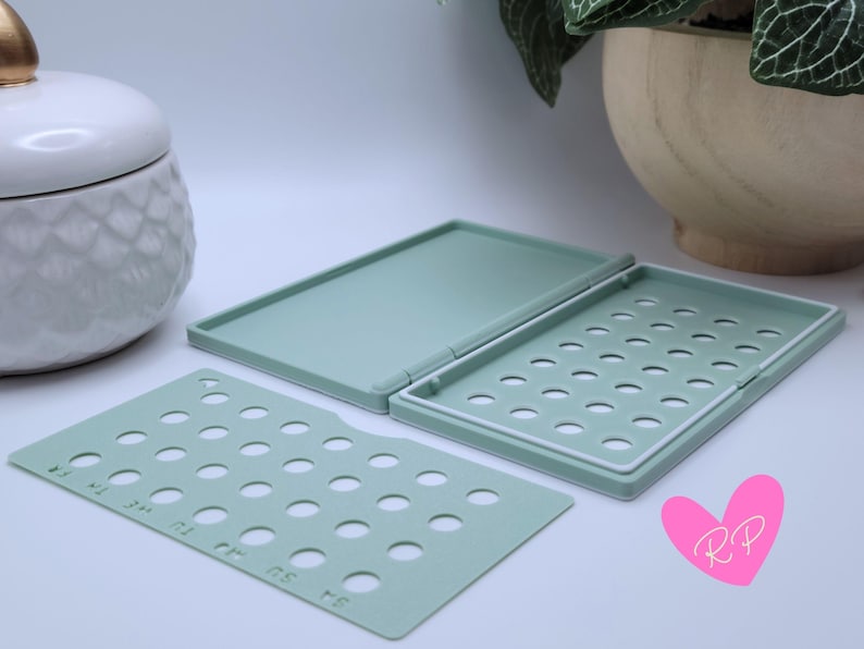 Mint green diamond-pattern pill case open with pack cover next to it – displays pill access holes and interior structure custom-fit for your birth control brand.