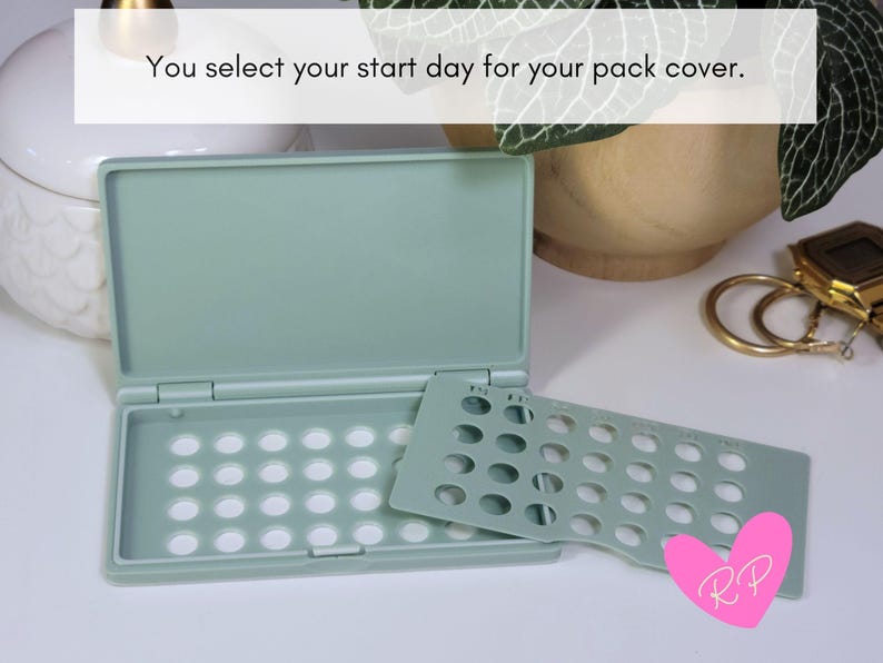 Open mint sea green birth control pill case with day-of-the-week pack cover leaning on it – shows secure cover system that marks your start day and holds the pill pack in place.