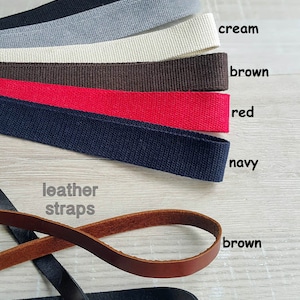 Op de afbeelding: Assortiment van katoenen banden in zwart, grijs, cr&egrave;me, bruin, rood en marine. Lederen banden in bruin en zwart.