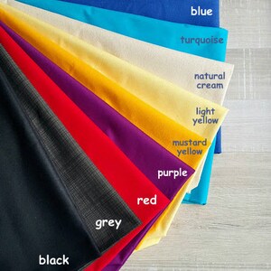 Op de afbeelding: Een verzameling stofstalen in verschillende kleuren, waaronder zwart, grijs, rood, paars, mosterdgeel, lichtgeel, natuurlijke cr&egrave;me, turquoise en blauw. De stalen zijn in een waaier vorm gerangschikt, met de donkerste kleur onderaan en de lichtste kleur bovenaan. De tekst "the colors of the lining" staat bovenaan de afbeelding.
