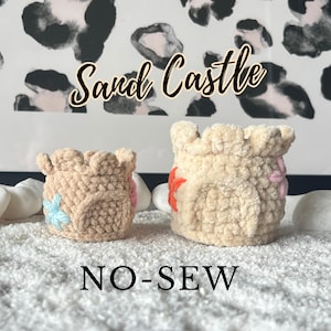 May include: Two crocheted sandcastle-shaped containers with colorful flower embellishments. The text "Sand Castle" and "NO-SEW" are visible in the image.