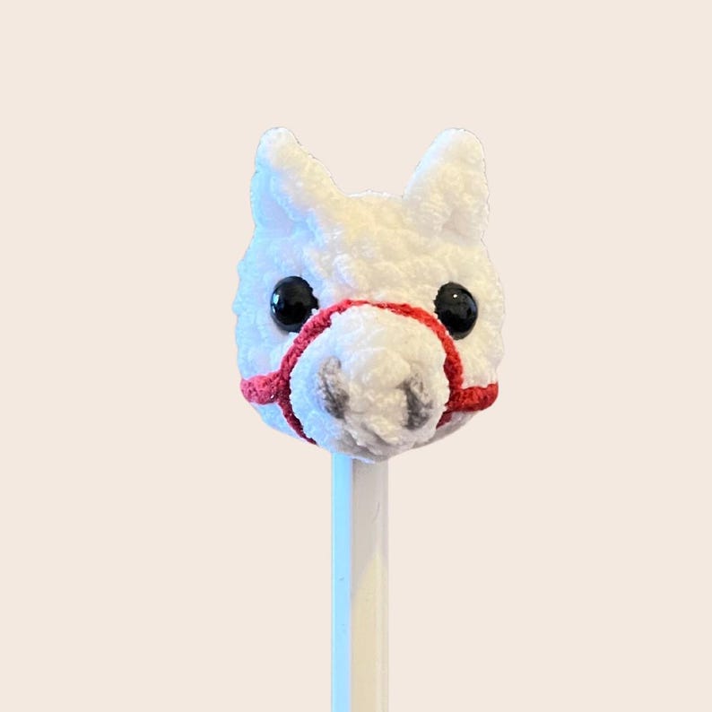 May include: White plush horse head with red bridle attached to a wooden pencil.